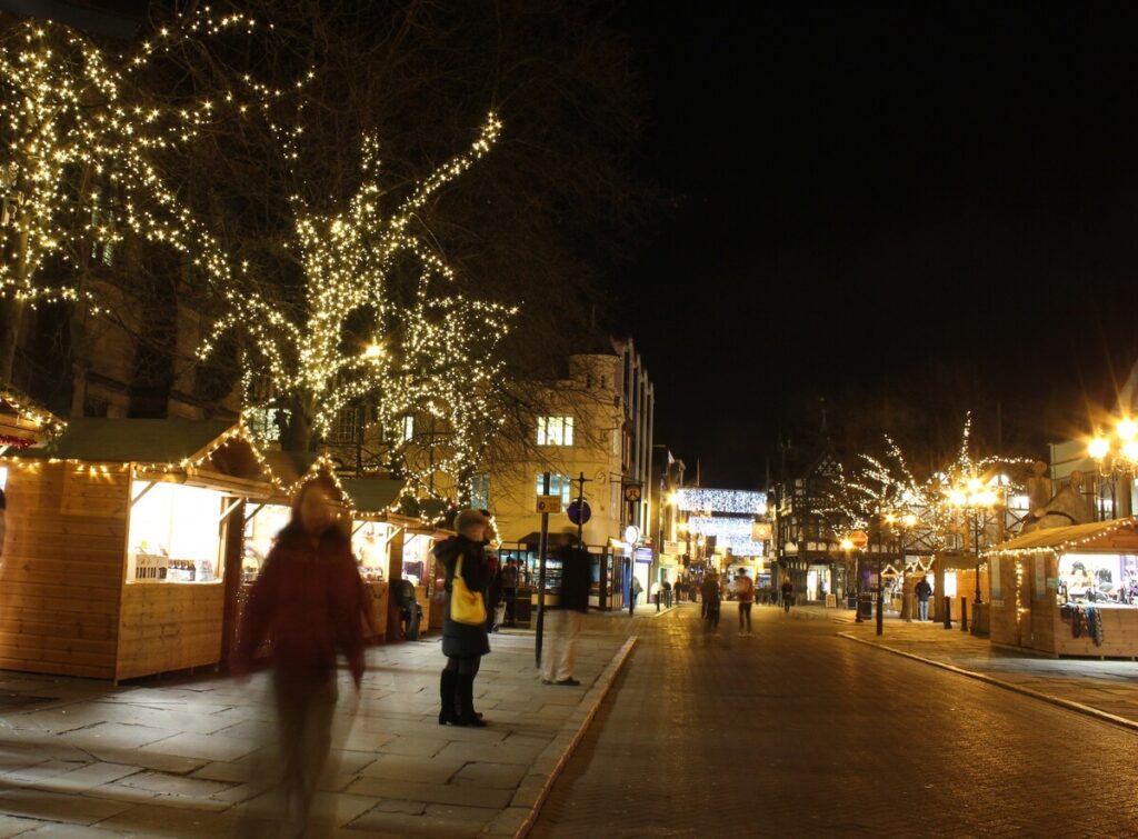Christmas lights and stalls on Northgate Street in Chester at night.