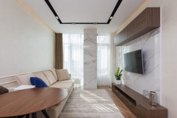Living room with a cream sofa, round wooden table and wooden storage